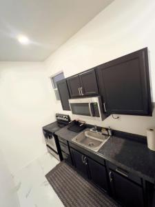 une cuisine avec un évier et un micro-ondes dans l'établissement Elegant 1-Bedroom Retreat, à Miami