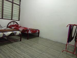 En eller flere senge i et værelse på Homestay D'Puteh