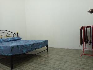 En eller flere senge i et værelse på Homestay D'Puteh