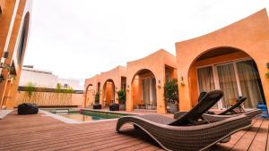 eine Terrasse mit Stühlen und einem Pool in einem Haus in der Unterkunft Villa Sorrento by SMS Hospitality in San Antonio