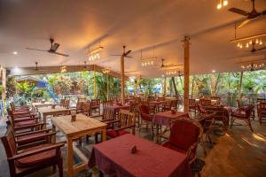 an empty restaurant with wooden tables and chairs at Rockit Cafe & Stay Palolem in Palolem