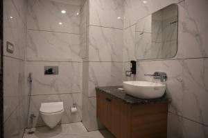 a white bathroom with a sink and a toilet at Florian Club Resort and Spa Jaipur in Jaipur +24 photos