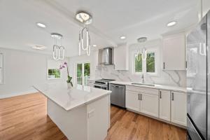 eine Küche mit weißen Schränken und einer weißen Arbeitsplatte in der Unterkunft Luxury 3-Bedroom House You Won't Want to Miss! in Randolph