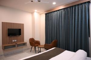 a hotel room with a bed and a television at Florian Club Resort and Spa Jaipur in Jaipur