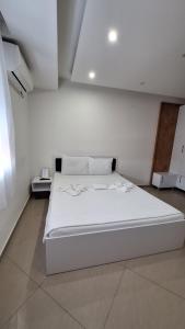 a large white bed in a white room at S-Apartmani Jagodina in Jagodina