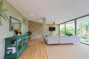 een woonkamer met een bank en een spiegel bij Villa Akwaba, Carbana Lodge, Koh Samui in Hua Thanon Beach