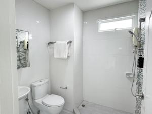 a white bathroom with a toilet and a shower at Blissful Heaven Residence at BTS Phromphong Emdistrict Shopping Area in Bangkok