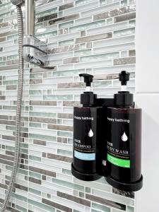 two bottles of bathroom products on a wall at Blissful Heaven Residence at BTS Phromphong Emdistrict Shopping Area in Bangkok