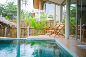 een huis met een zwembad en twee stoelen ernaast bij Villa Akwaba, Carbana Lodge, Koh Samui in Hua Thanon Beach