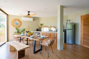 een keuken met een tafel, stoelen en een koelkast bij Villa Akwaba, Carbana Lodge, Koh Samui in Hua Thanon Beach