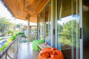 een afgeschermde veranda met een bank en een tafel bij Villa Akwaba, Carbana Lodge, Koh Samui in Hua Thanon Beach