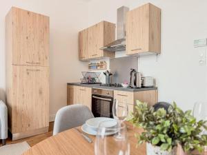 een keuken met houten kasten en een houten tafel bij Loft Parking included in Metz +13 foto's