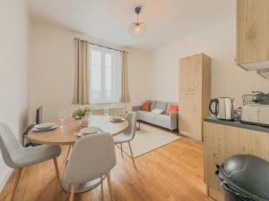 een keuken en een woonkamer met een tafel en stoelen bij Loft Parking included in Metz