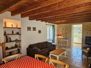 Gîte Le p'tit nid de Montachon, Saulieu, Morvan في Saint-Didier: غرفة معيشة بها أريكة وطاولة