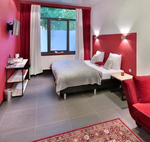 una camera da letto con un letto e una parete rossa di Hotel Moon a Sint-Niklaas