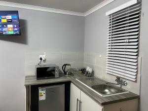 a small kitchen with a sink and a microwave at Awezi Overnight in Coldstream +12 photos