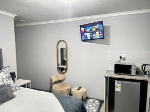 a room with a bed and a tv on the wall at Awezi Overnight in Coldstream