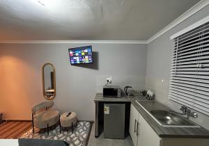 a kitchen with a sink and a counter with two chairs at Awezi Overnight in Coldstream