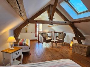 Gîte Le p'tit nid de Montachon, Saulieu, Morvan في Saint-Didier: غرفة علوية بسرير وطاولة وكراسي