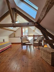 Gîte Le p'tit nid de Montachon, Saulieu, Morvan في Saint-Didier: غرفة علوية بها سرير وكرسيان وطاولة