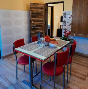 un tavolo da pranzo con sedie rosse e un tavolino di Asha's homestay a Rāmgarh