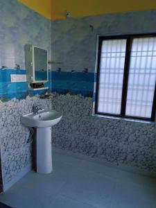un bagno con lavandino e finestra di Asha's homestay a Rāmgarh