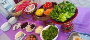 a purple table topped with bowls of vegetables and eggs at Sukhothaigrand hotel and landmark in Ban Pak Khlong