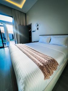 un grande letto bianco in una stanza con una finestra di شاليه الجنان a á¸¨arÄdÄ«