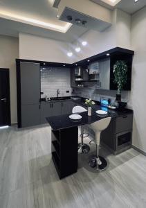 una cucina con isola nera in una camera di شاليه الجنان a á¸¨arÄdÄ«