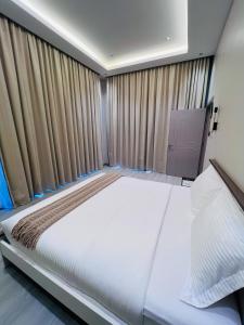 una camera da letto con un grande letto bianco con tende di شاليه الجنان a á¸¨arÄdÄ«