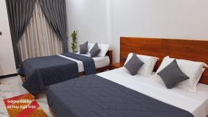 een slaapkamer met 2 bedden met blauwe en witte lakens bij Green inn Trinco in Uppuveli