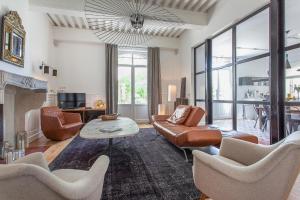 een woonkamer met lederen meubels en een open haard bij Maison TANDEM in Cluny