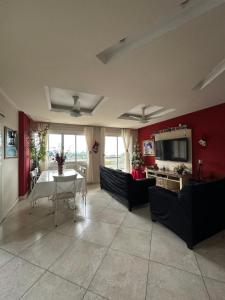 ein Wohnzimmer mit roten Wänden, einem Tisch und Stühlen in der Unterkunft Casa com Belas vistas - Muriqui in Mangaratiba