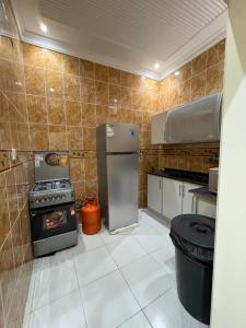 una cocina con refrigerador y estufa en Alzahra residence 4 km to AlHaram, en La Meca
