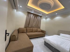 una sala de estar con un sofá y una cama en Alzahra residence 4 km to AlHaram, en La Meca