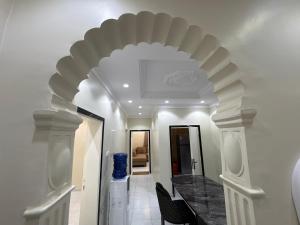 un pasillo con un arco en una casa en Alzahra residence 4 km to AlHaram, en La Meca