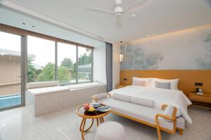 a bedroom with a large bed and a large window at Wyndham Garden Phuket Kamala in Kamala Beach