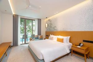a bedroom with a large bed and a large window at Wyndham Garden Phuket Kamala in Kamala Beach