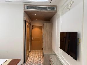 a hallway with a television on a wall and a door at Hotel The Raghavas' in Ayodhya
