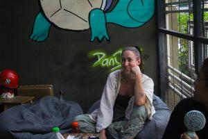 a woman sitting on a bed in a room at Here We Go Bangkok in Bangkok