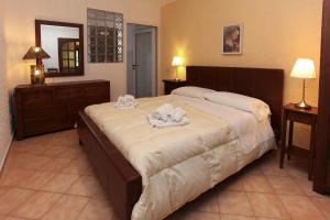 a bedroom with a large bed with towels on it at Villa Eleanto in Cefalù
