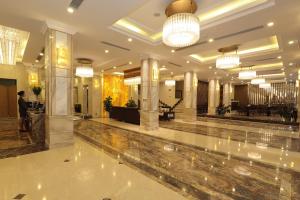 vestíbulo de un hotel con suelo de mármol y lámparas de araña en Sapa Legend Hotel & Spa, en Sa Pa