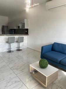 een woonkamer met een blauwe bank en een tafel bij Departamento Céntrico in Monterrey