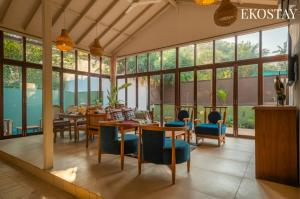 a dining room with a table and chairs and windows at EKOSTAY - Assa Villa in Marna +21 photos
