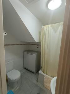 Un baño blanco con inodoro y lavabo. en Casa playa El Ancla Puerto Santa María, en El Puerto de Santa María 24 fotos más