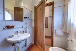 W łazience znajduje się umywalka, toaleta i lustro. w obiekcie Agriturismo La Presura w mieście Strada
