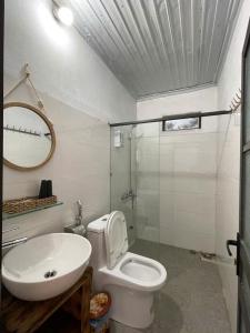 Un baño con inodoro, lavabo y espejo. en O'Chau Meo Vac Homestay Ha Giang, en Mèo Vạc