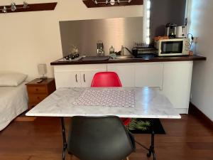 ブーライユにあるBourail take restのテーブルと電子レンジのある小さなキッチン