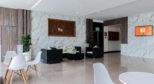 Ban Nam ThongにあるB2 Lampang Boutique & Budget Hotelの白い椅子とテーブルとソファのあるロビー