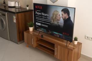 TV de pantalla plana grande con soporte de madera en New Modern Studio in Downtown 4, en Kenitra